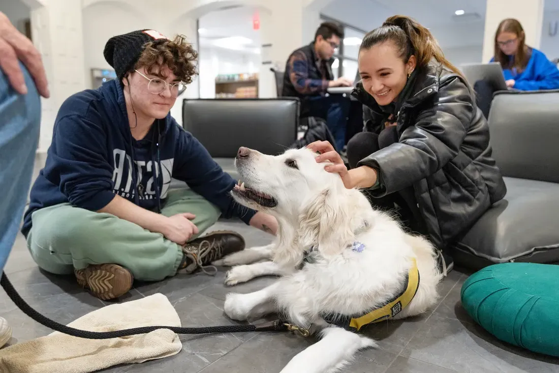 Students with pet therapy dog outside at the Barnes Center.